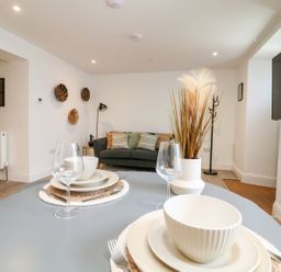 A living room with a sofa and dining table at Klysa in Camborne