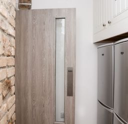 A kitchen with a door and refrigerator at Teylu in Camborne