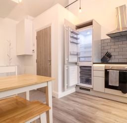 A kitchen with an open refrigerator and a table at Battell Chambers in Camborne
