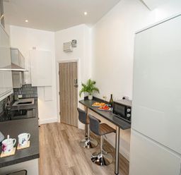 A kitchen with a countertop and bar stools at Daniel Chambers in Camborne