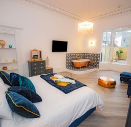 A bedroom with a bed and bathtub at Mews Retreat in Camborne