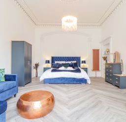 A bedroom with a bed and sofa at Mews Retreat in Camborne