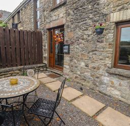 An outdoor seating area with a table and chairs at Gwyn Studio in Aberdare