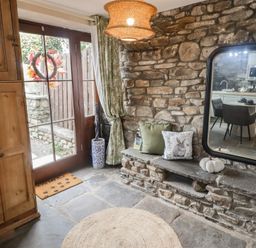 An entrance with a stone wall and door at Gwyn Studio in Aberdare