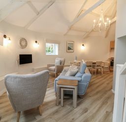 A living room with a sofa and dining table at Round Barn in Ilfracombe