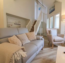 A living room with a sofa and staircase at Round Barn in Ilfracombe