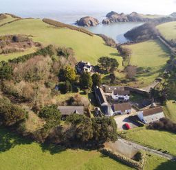 An aerial view of a property surrounded by greenery and water at Round Barn in Ilfracombe