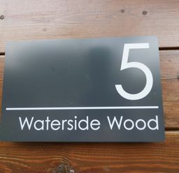 A sign displaying number 5 and the name Waterside Wood