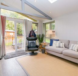 A living room with a sofa, chair, and coffee table at 5 Waterside Wood in Troutbeck Bridge