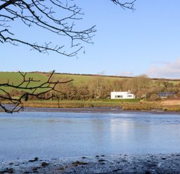 A house with solar panels by the water at Bryncyn in Newport, Pembrokeshire