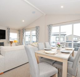 A living room with a dining area and a television at 2 Summerleaze in Bude