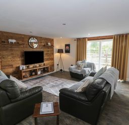 A living room with sofas and a television at Pompian Lodge Leyland