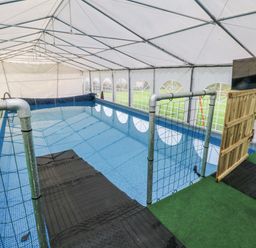 An indoor pool area with a fence and a door at Pompian Lodge Bretherton near Tarleton