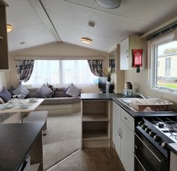 A living room with a couch and kitchen area at 123 Elms