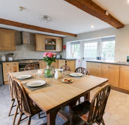 A kitchen with a wooden table and chairs at Secret Garden Cottage in Ciliau Aeron near Aberaeron