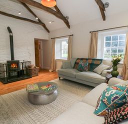 A living room with a fireplace and a coffee table at Secret Garden Cottage in Ciliau Aeron near Aberaeron