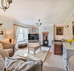 A living room with a sofa and a fireplace at The Old Farm House near Pelynt
