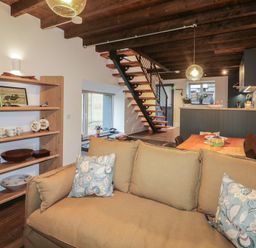 A living room with a staircase and kitchen area at The Loft in Glenmore, County Kilkenny