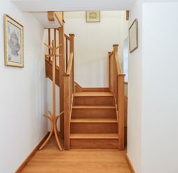 A staircase and coat rack in a hallway at Hilldown Granary near Bow