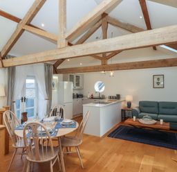 A living room with a dining area and kitchen at Hilldown Granary near Bow
