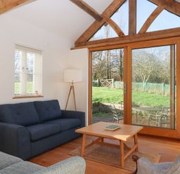 A living room with a sofa and a table at Hilldown Cott near Bow