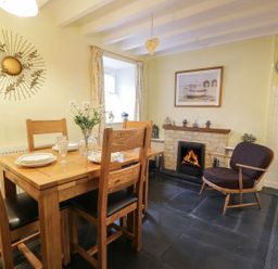 A dining room with a table and chairs at Noddfa in Penmachno
