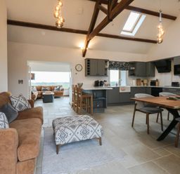 A living room and kitchen area with furniture at 2 Trem Y Mor Llanfwrog near Llanfachraeth