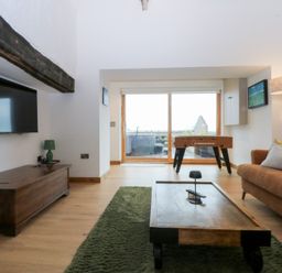 A living room with a foosball table and a sofa at Hen Penmynydd in Llanfwrog near Llanfachraeth