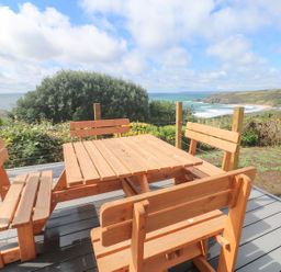 A wooden table with benches overlooking the sea at Shearwater in Praa Sands