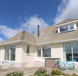 A house exterior with windows, door, and garden furniture at Shearwater in Praa Sands