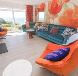 A living room with a sofa and armchairs at Shearwater, Praa Sands