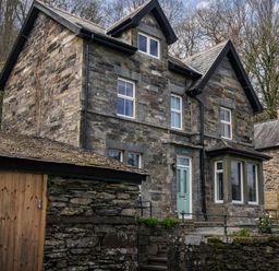 An outdoor view of a stone house with a garden at Green Bank in Betws-Y-Coed