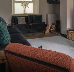 A living room with a sofa, television, and a fireplace at Green Bank in Betws-Y-Coed