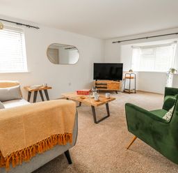 A living room with a sofa and coffee table at Long Barn in Burton Bradstock