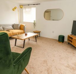 A living room with a sofa and coffee table at Long Barn in Burton Bradstock