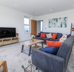 A living room with a sofa and television at Seafern House 36B in Poole