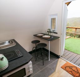 A kitchen with a sink and dining area at Cwtch Bach in Aberdare