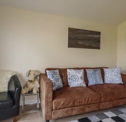 A living room with a sofa and armchair at Stanbury in St Merryn