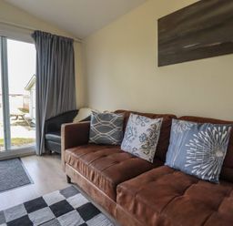A living room with a sofa and pillows at Stanbury in St Merryn