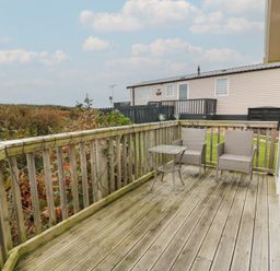 A deck with table and chairs at Peaceful in Stranraer