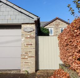 The exterior of a property with a garage and a gate at The Mizzen in St Endellion near Port Isaac