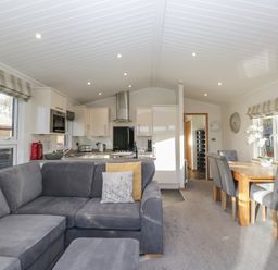 A living room with a kitchen and dining space at Bluebell Lodge in Warton