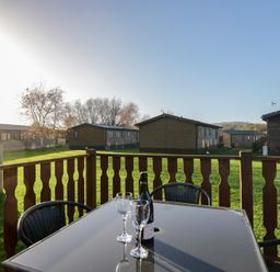 An outdoor area with a table and chairs at Bluebell Lodge in Warton