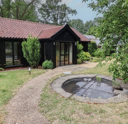An outdoor area with a pond and a gravel path at Owl Cottage Kettleburgh near Framlingham