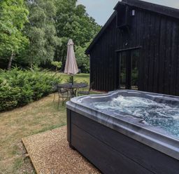 A hot tub and seating area at Owl Cottage in Kettleburgh near Framlingham