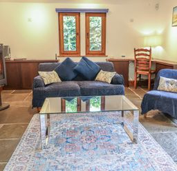 A living room with a sofa and coffee table at Owl Cottage in Kettleburgh near Framlingham
