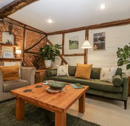 A living room with a sofa and armchair at Magpie Cottage in Worcester