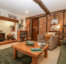 A living room with a stove and bookshelves at Magpie Cottage in Worcester