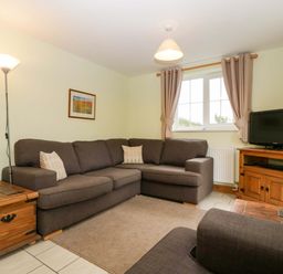 A living room with a sofa and television at Orchard Cottage in Corse near Gloucester