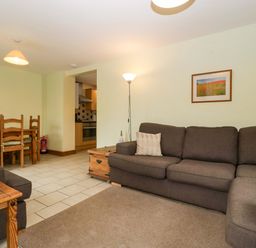 A living room with a sofa and dining area at Orchard Cottage in Corse near Gloucester